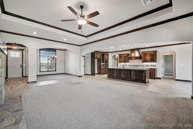 9015 N 65th E Pl, Owasso, OK 74055 - unfurnished living room featuring crown molding, arched walkways, a sink, recessed lighting, and baseboards