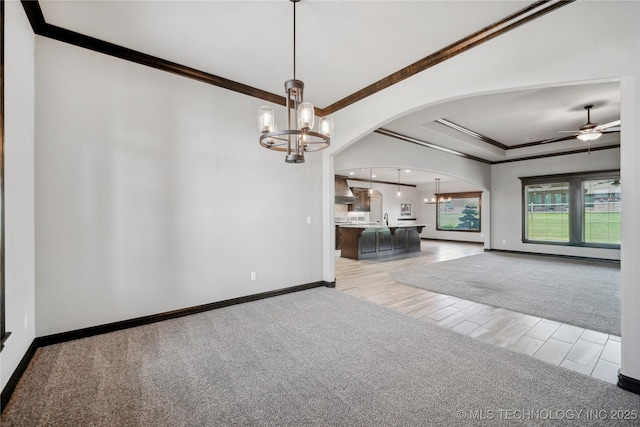 9015 N 65th E Pl, Owasso, OK 74055 - empty room featuring arched walkways, a chandelier, ornamental molding, baseboards, and ceiling fan