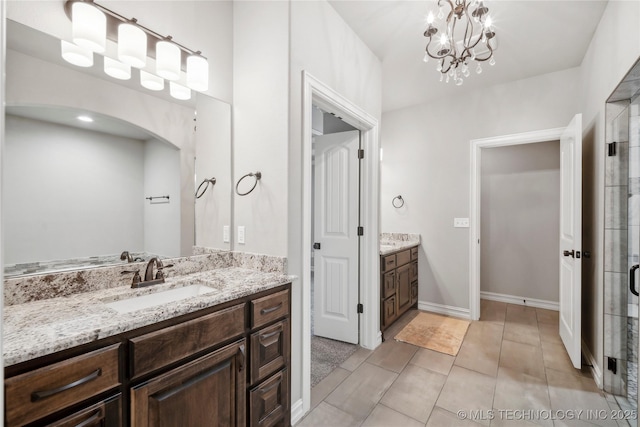 9015 N 65th E Pl, Owasso, OK 74055 - full bathroom with two vanities, a chandelier, a stall shower, tile patterned flooring, and baseboards