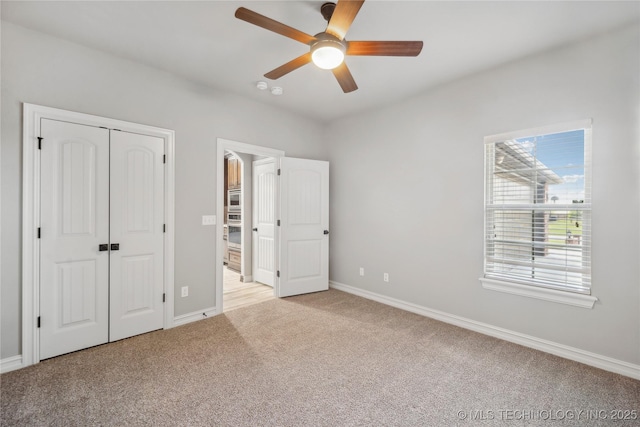 9015 N 65th E Pl, Owasso, OK 74055 - unfurnished bedroom with light carpet, baseboards, a ceiling fan, and a closet