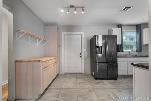1228 S Erie Ave, Tulsa, OK 74112 - kitchen with stainless steel fridge with ice dispenser, open shelves, light marble finish flooring, and white cabinets