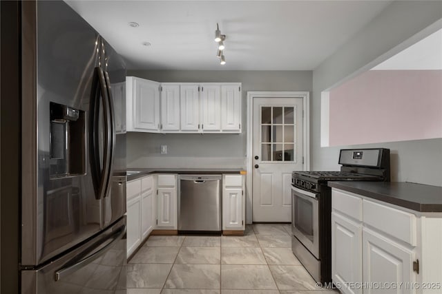 1228 S Erie Ave, Tulsa, OK 74112 - kitchen featuring appliances with stainless steel finishes, dark countertops, white cabinetry, and light marble finish floors