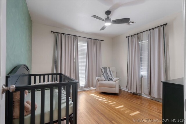 1228 S Erie Ave, Tulsa, OK 74112 - bedroom with light wood-style floors, a nursery area, and a ceiling fan