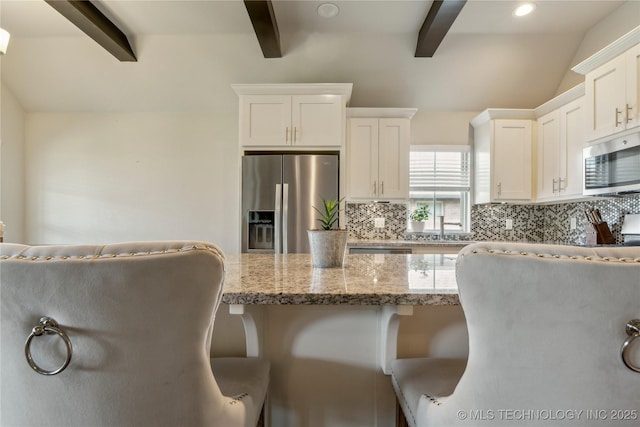 18403 E 50th St, Tulsa, OK 74134 - kitchen featuring stainless steel appliances, beam ceiling, decorative backsplash, a kitchen bar, and light stone counters