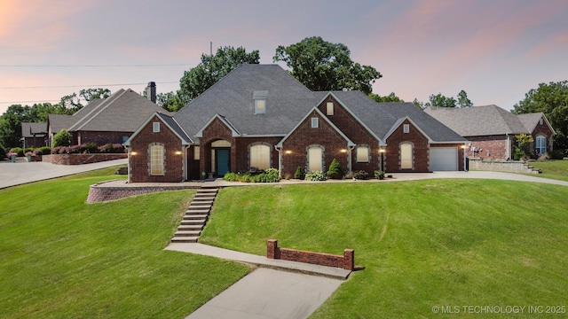 316 E 44th St, Sand Springs, OK 74063 - view of front facade with driveway, brick siding, a yard, and a garage