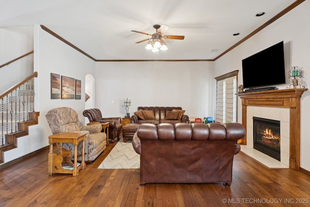 316 E 44th St, Sand Springs, OK 74063 - living room with a ceiling fan, hardwood / wood-style floors, ornamental molding, a tiled fireplace, and stairs