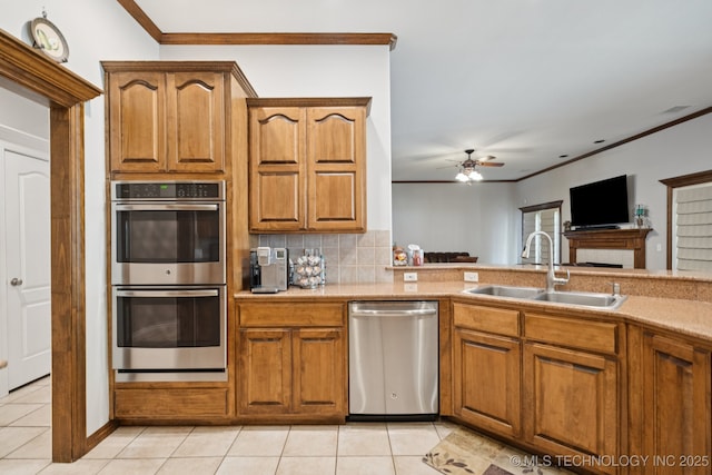 316 E 44th St, Sand Springs, OK 74063 - kitchen with appliances with stainless steel finishes, ornamental molding, ceiling fan, light tile patterned flooring, and brown cabinets