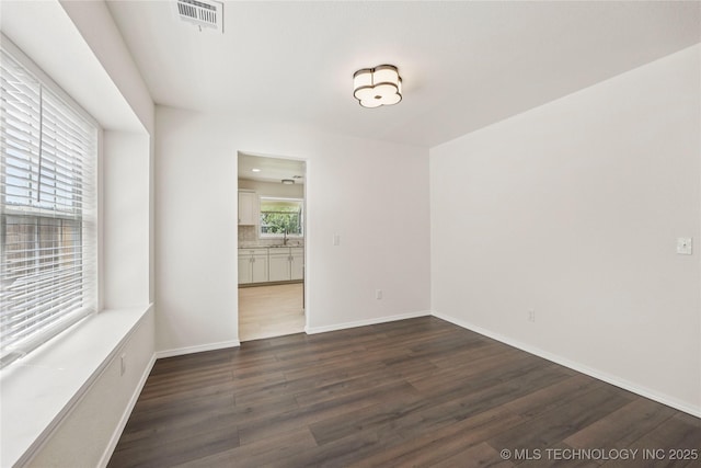 2817 W Oakland St, Broken Arrow, OK 74012 - unfurnished room featuring dark wood finished floors, a sink, and baseboards