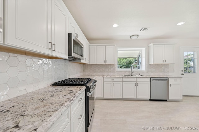 2817 W Oakland St, Broken Arrow, OK 74012 - kitchen with stainless steel appliances, a sink, healthy amount of natural light, white cabinetry, and recessed lighting