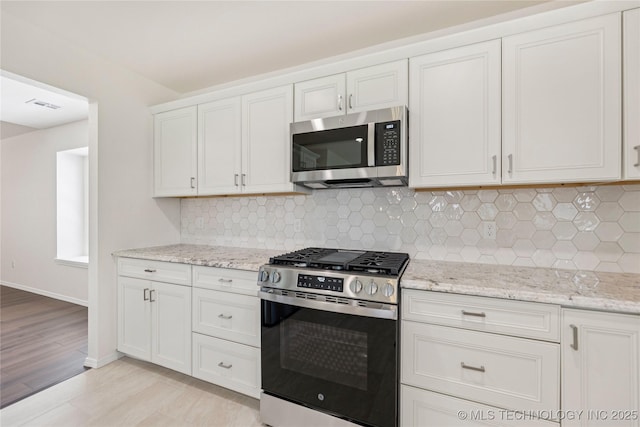 2817 W Oakland St, Broken Arrow, OK 74012 - kitchen with stainless steel appliances, light wood-style flooring, light stone counters, and white cabinetry