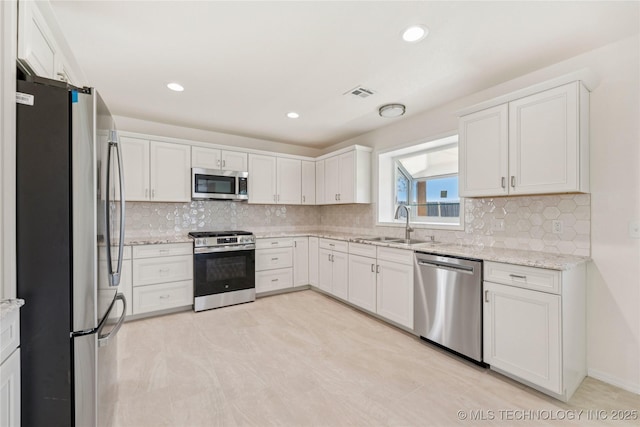 2817 W Oakland St, Broken Arrow, OK 74012 - kitchen with stainless steel appliances, a sink, white cabinetry, tasteful backsplash, and recessed lighting