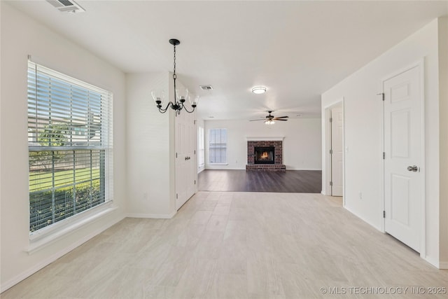 2817 W Oakland St, Broken Arrow, OK 74012 - unfurnished living room featuring a chandelier, a brick fireplace, a ceiling fan, and baseboards