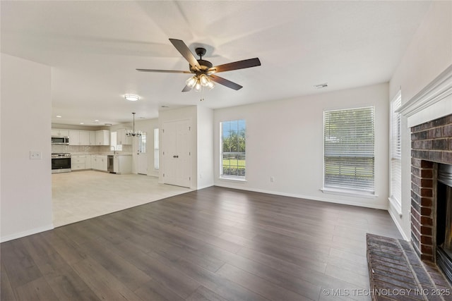 2817 W Oakland St, Broken Arrow, OK 74012 - unfurnished living room with a fireplace, a ceiling fan, baseboards, wood finished floors, and a chandelier