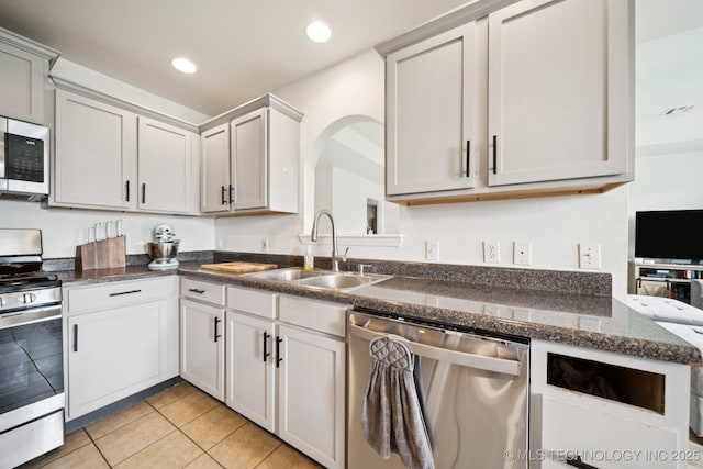 510 S Creek St, Skiatook, OK 74070 - kitchen with appliances with stainless steel finishes, a sink, light tile patterned floors, recessed lighting, and arched walkways
