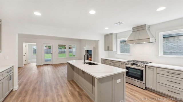2508 W Birmingham St, Broken Arrow, OK 74011 - kitchen with premium range hood, stainless steel range with gas stovetop, gray cabinetry, a center island with sink, and tasteful backsplash