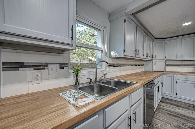1228 D St NW, Ardmore, OK 73401 - kitchen with butcher block countertops, a sink, decorative backsplash, recessed lighting, and a textured ceiling