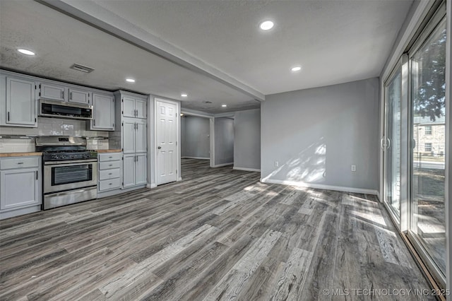 1228 D St NW, Ardmore, OK 73401 - kitchen featuring stainless steel appliances, wood finished floors, baseboards, wooden counters, and decorative backsplash