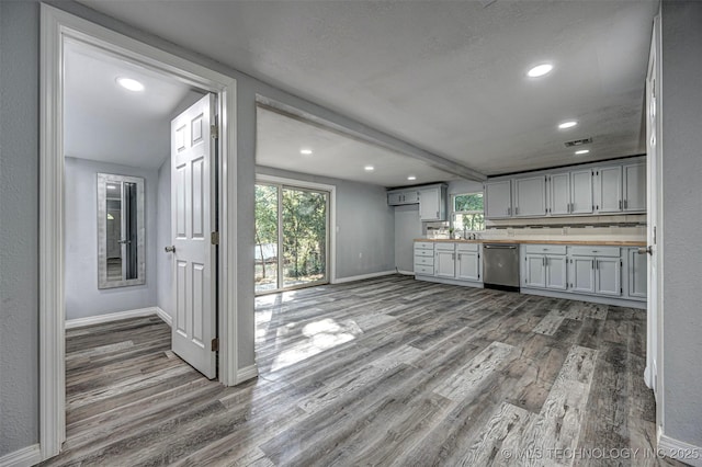 1228 D St NW, Ardmore, OK 73401 - kitchen with stainless steel dishwasher, wood finished floors, baseboards, and recessed lighting