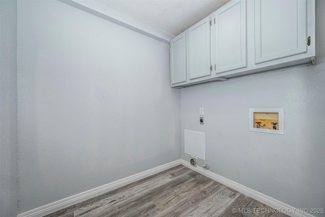 1228 D St NW, Ardmore, OK 73401 - laundry area with cabinet space, hookup for a washing machine, hookup for an electric dryer, wood finished floors, and baseboards