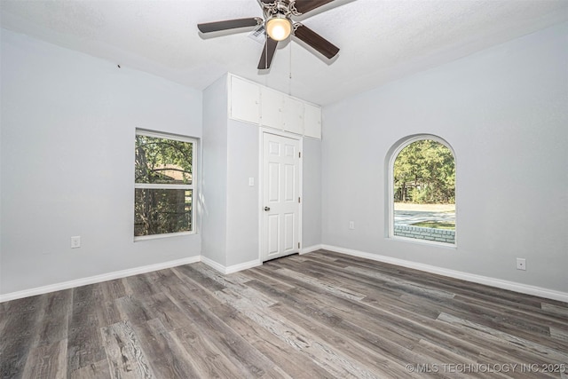 1228 D St NW, Ardmore, OK 73401 - unfurnished room with healthy amount of natural light, wood finished floors, ceiling fan, and baseboards