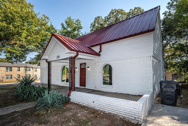 1228 D St NW, Ardmore, OK 73401 - view of front of house featuring brick siding and metal roof
