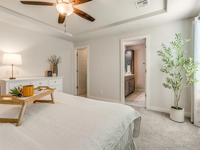 7221 S Indianwood Ave, Broken Arrow, OK 74011 - bedroom with baseboards, light carpet, ensuite bathroom, a ceiling fan, and a tray ceiling