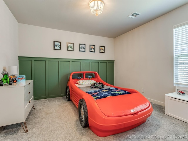 7221 S Indianwood Ave, Broken Arrow, OK 74011 - bedroom featuring light carpet, multiple windows, a wainscoted wall, and a decorative wall