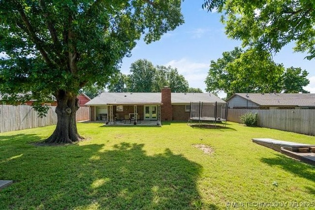 1138 N Gum Ave, Broken Arrow, OK 74012 - rear view of house featuring a trampoline, a chimney, and a patio