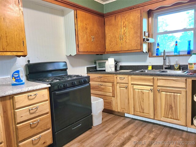 1950 Cedar Bluff Rd, Fort Gibson, OK 74434 - kitchen featuring black range with gas stovetop, a sink, light wood-style flooring, and brown cabinets