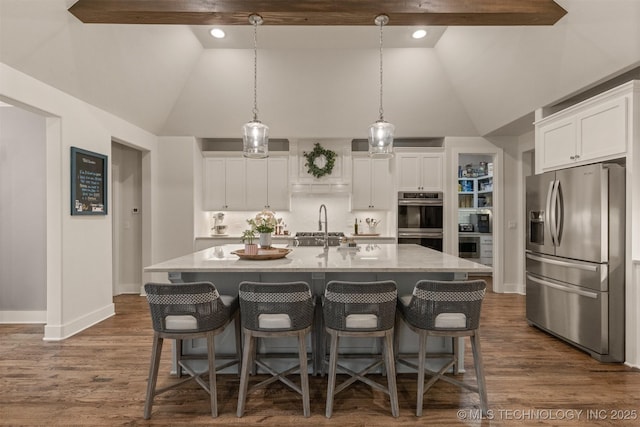 6705 S Palm Ave, Broken Arrow, OK 74011 - kitchen featuring appliances with stainless steel finishes, white cabinets, a center island with sink, a kitchen bar, and high vaulted ceiling