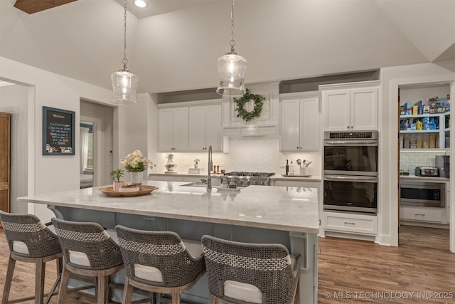6705 S Palm Ave, Broken Arrow, OK 74011 - kitchen featuring stainless steel appliances, a sink, decorative backsplash, white cabinets, and high vaulted ceiling