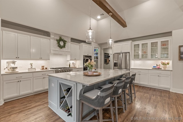 6705 S Palm Ave, Broken Arrow, OK 74011 - kitchen featuring a center island, white cabinetry, beamed ceiling, appliances with stainless steel finishes, and decorative backsplash