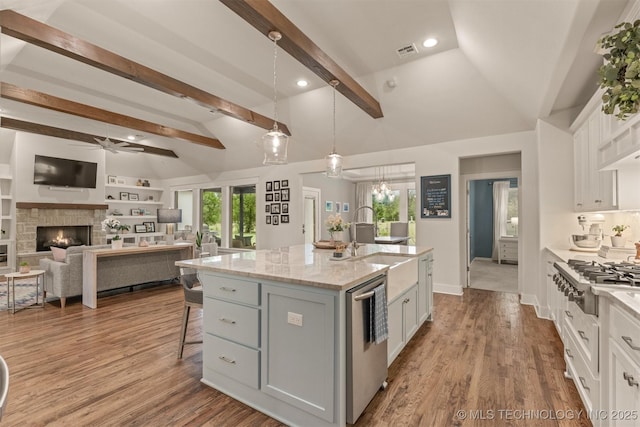 6705 S Palm Ave, Broken Arrow, OK 74011 - kitchen with appliances with stainless steel finishes, a ceiling fan, a sink, a kitchen bar, and white cabinetry