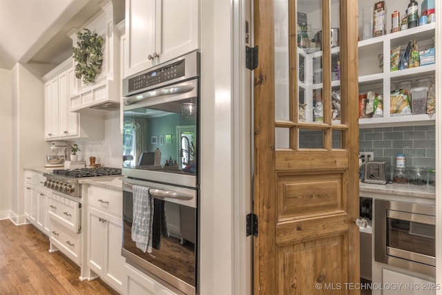 6705 S Palm Ave, Broken Arrow, OK 74011 - kitchen with stainless steel appliances, tasteful backsplash, white cabinets, light wood finished floors, and light stone counters