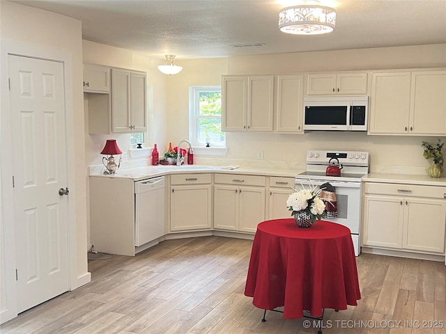 11522 E 64th St, Broken Arrow, OK 74012 - kitchen with white appliances, light wood-style flooring, light countertops, a sink, and white cabinets