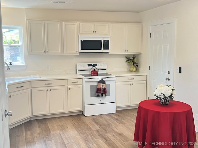 11522 E 64th St, Broken Arrow, OK 74012 - kitchen with white appliances, light wood finished floors, and light countertops