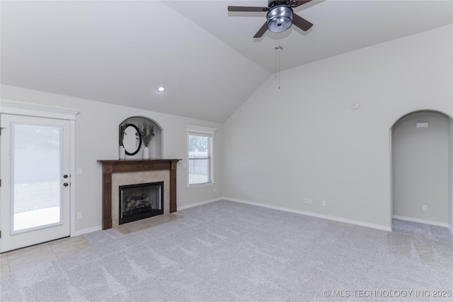 9241 N 144th E Ave, Owasso, OK 74055 - unfurnished living room with light carpet, ceiling fan, a tile fireplace, lofted ceiling, and arched walkways