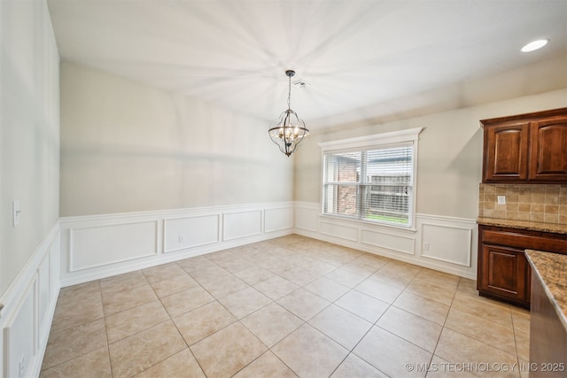 9241 N 144th E Ave, Owasso, OK 74055 - unfurnished dining area featuring a decorative wall, a chandelier, wainscoting, and light tile patterned floors