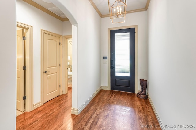 1412 E 37th St, Tulsa, OK 74105 - entryway with crown molding, wood finished floors, arched walkways, baseboards, and a chandelier