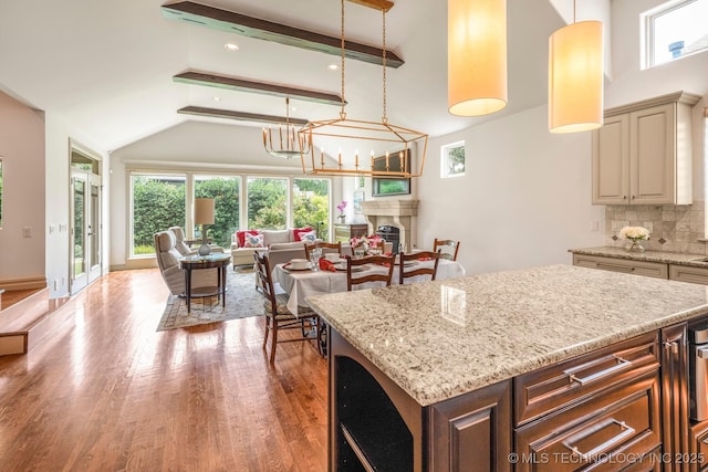 1412 E 37th St, Tulsa, OK 74105 - kitchen featuring open floor plan, wood finished floors, beam ceiling, light stone countertops, and backsplash