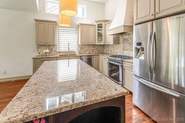 1412 E 37th St, Tulsa, OK 74105 - kitchen featuring appliances with stainless steel finishes, premium range hood, a sink, cream cabinetry, and plenty of natural light