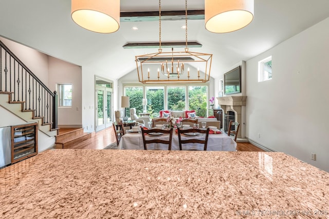 1412 E 37th St, Tulsa, OK 74105 - dining area with wood finished floors, a chandelier, stairs, baseboards, and a tiled fireplace