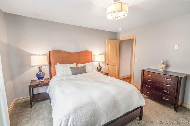 1412 E 37th St, Tulsa, OK 74105 - bedroom with light carpet, baseboards, and a chandelier