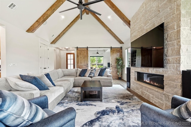 3406 W Quantico Pl, Broken Arrow, OK 74011 - living room with a ceiling fan, high vaulted ceiling, beam ceiling, a barn door, and a fireplace