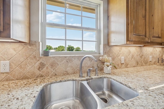 6200 E 340th Rd, Talala, OK 74080 - kitchen featuring brown cabinetry, tasteful backsplash, and light stone countertops