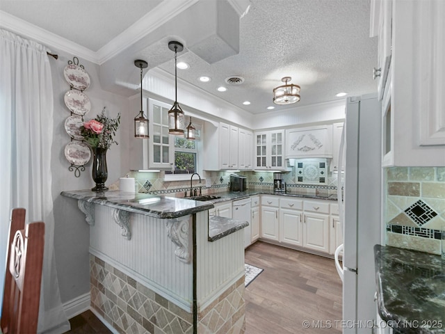 402 Beaumont Dr, Ardmore, OK 73401 - kitchen with a peninsula, a sink, glass insert cabinets, white cabinets, and ornamental molding