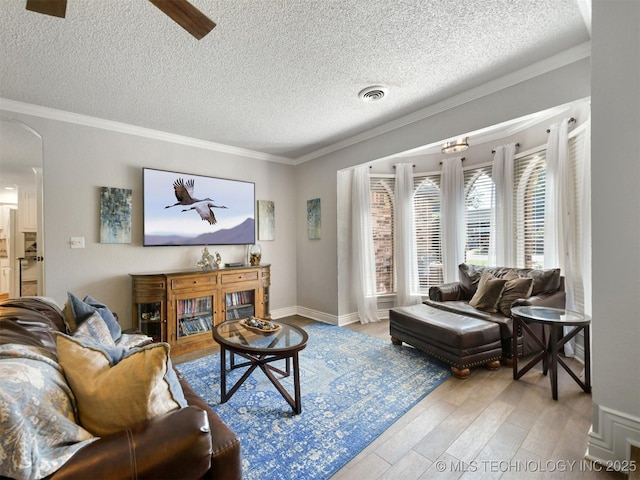 402 Beaumont Dr, Ardmore, OK 73401 - living room featuring wood finished floors, a textured ceiling, arched walkways, ceiling fan, and ornamental molding