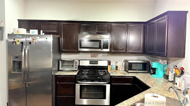 5752 E 147th St S, Bixby, OK 74008 - kitchen with stainless steel appliances, dark brown cabinets, and light stone counters