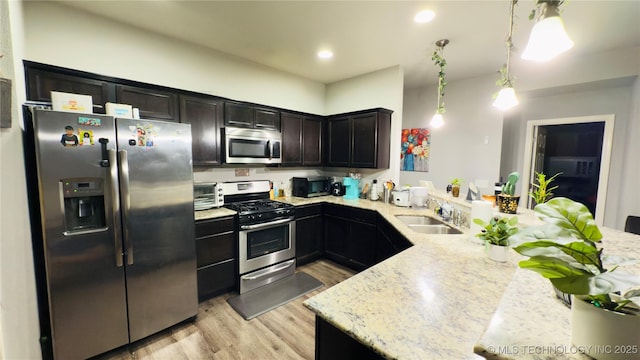 5752 E 147th St S, Bixby, OK 74008 - kitchen featuring stainless steel appliances, a sink, a peninsula, light wood finished floors, and light stone countertops
