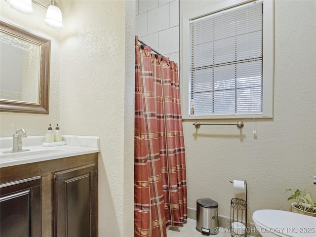 5792 W Lain Lake Rd, Atoka, OK 74525 - bathroom with toilet, vanity, a shower with shower curtain, and a textured wall